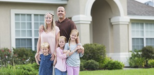 family standing in front of house